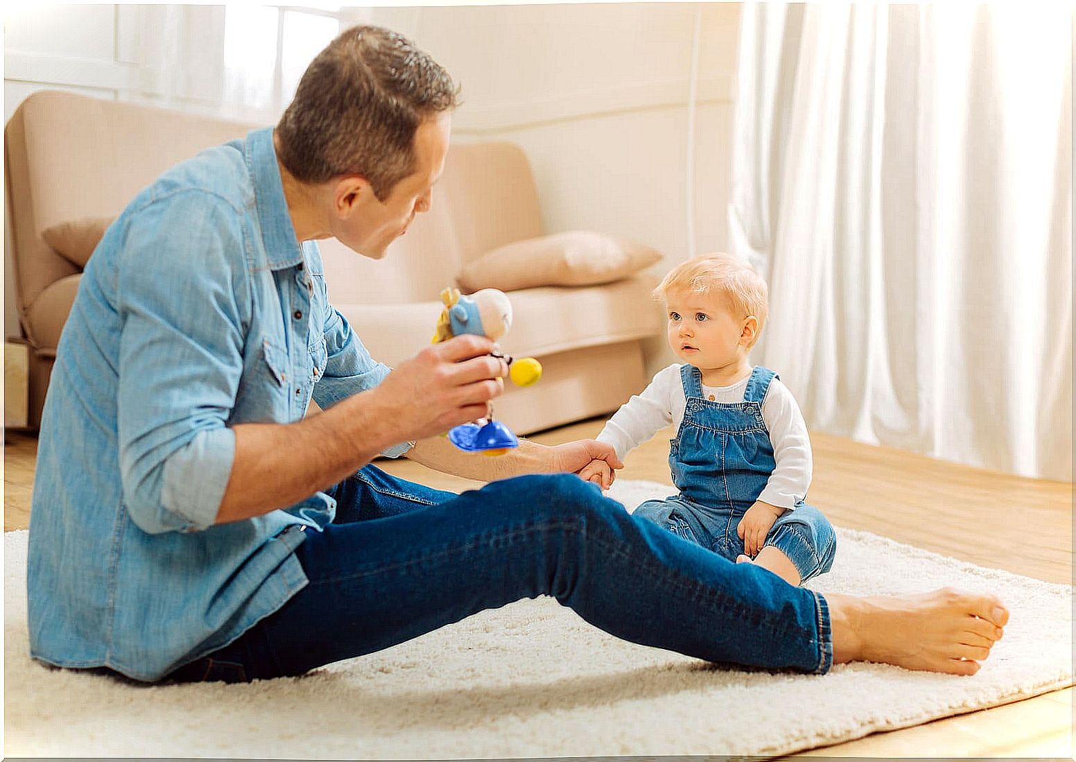 Dad communicating with his baby and talking to him using techniques to strengthen the child's communication skills.