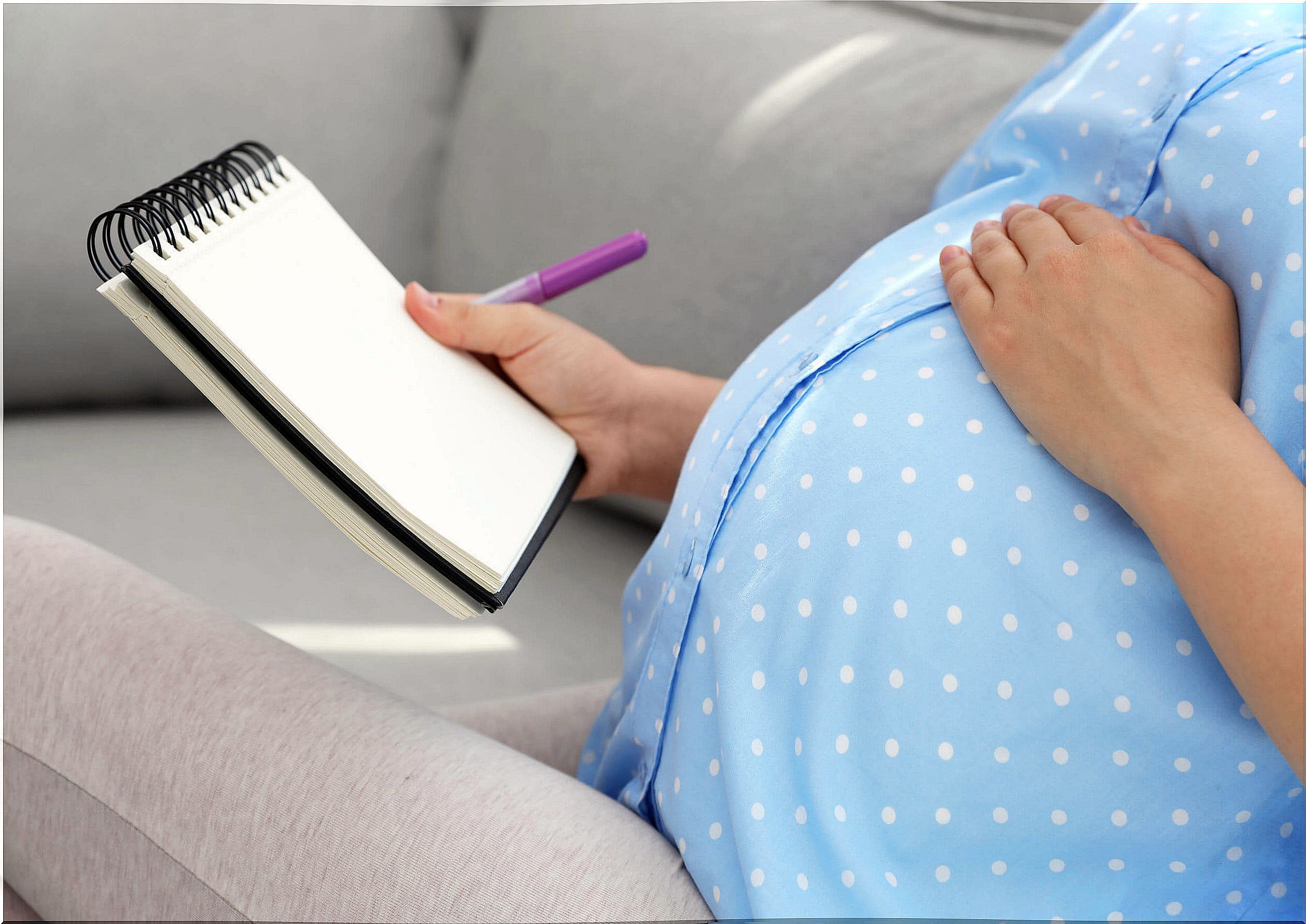 Pregnant woman thinking and writing down elven baby names.