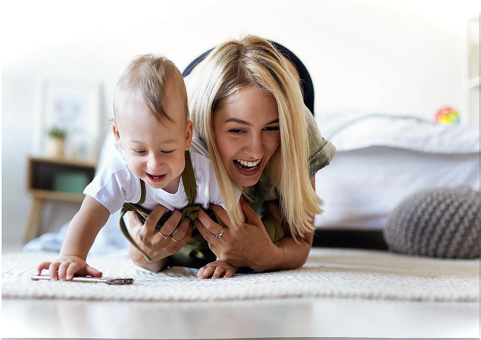 Mom doing exercises for the development of the baby from 7 to 9 months with her son.