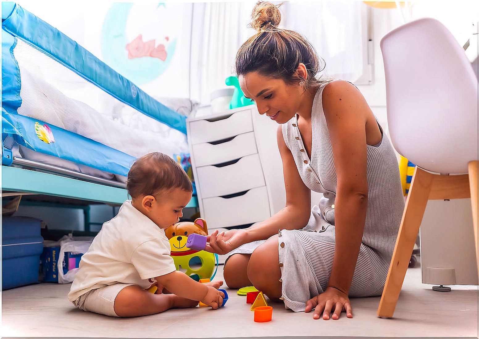 Mother doing exercises for the development of the baby of 10 to 12 months with her son.