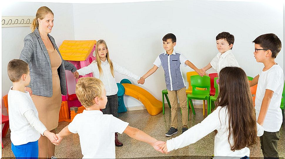 Children taking active breaks in class holding hands in a circle.