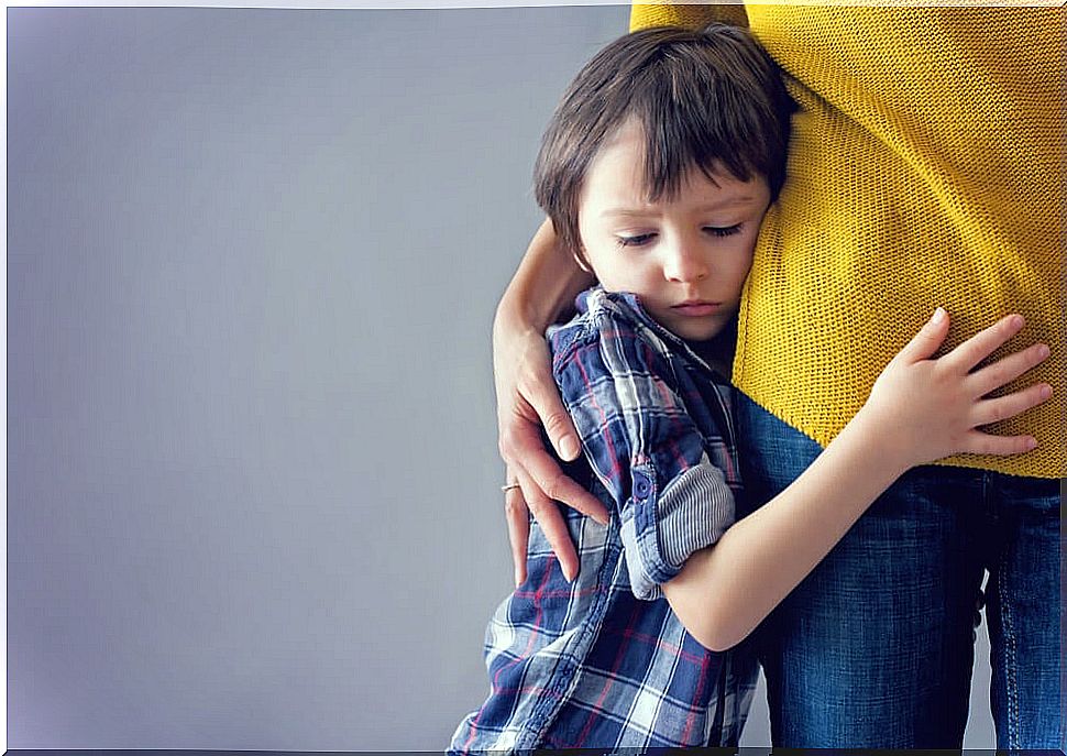 Boy hugging his mother in fear because he suffers from cabin syndrome.