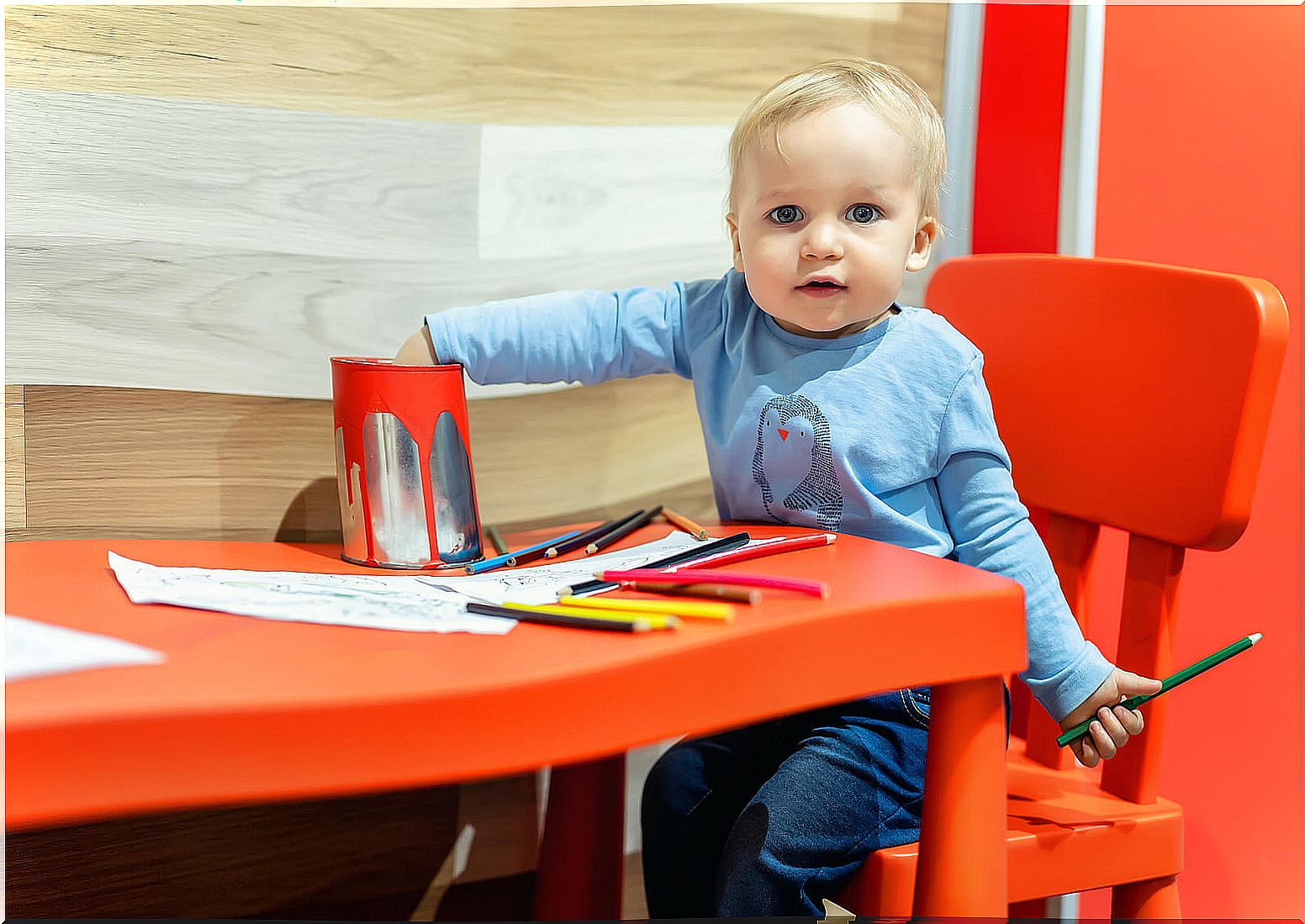 Child drawing with many colors, because drawing is the first writing of the little ones.