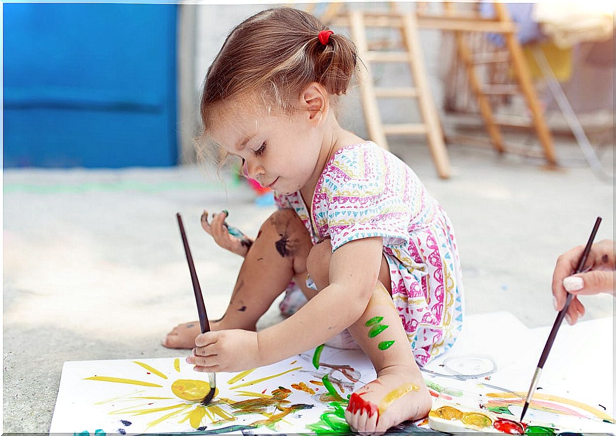 Little girl painting and exploring her creativity.