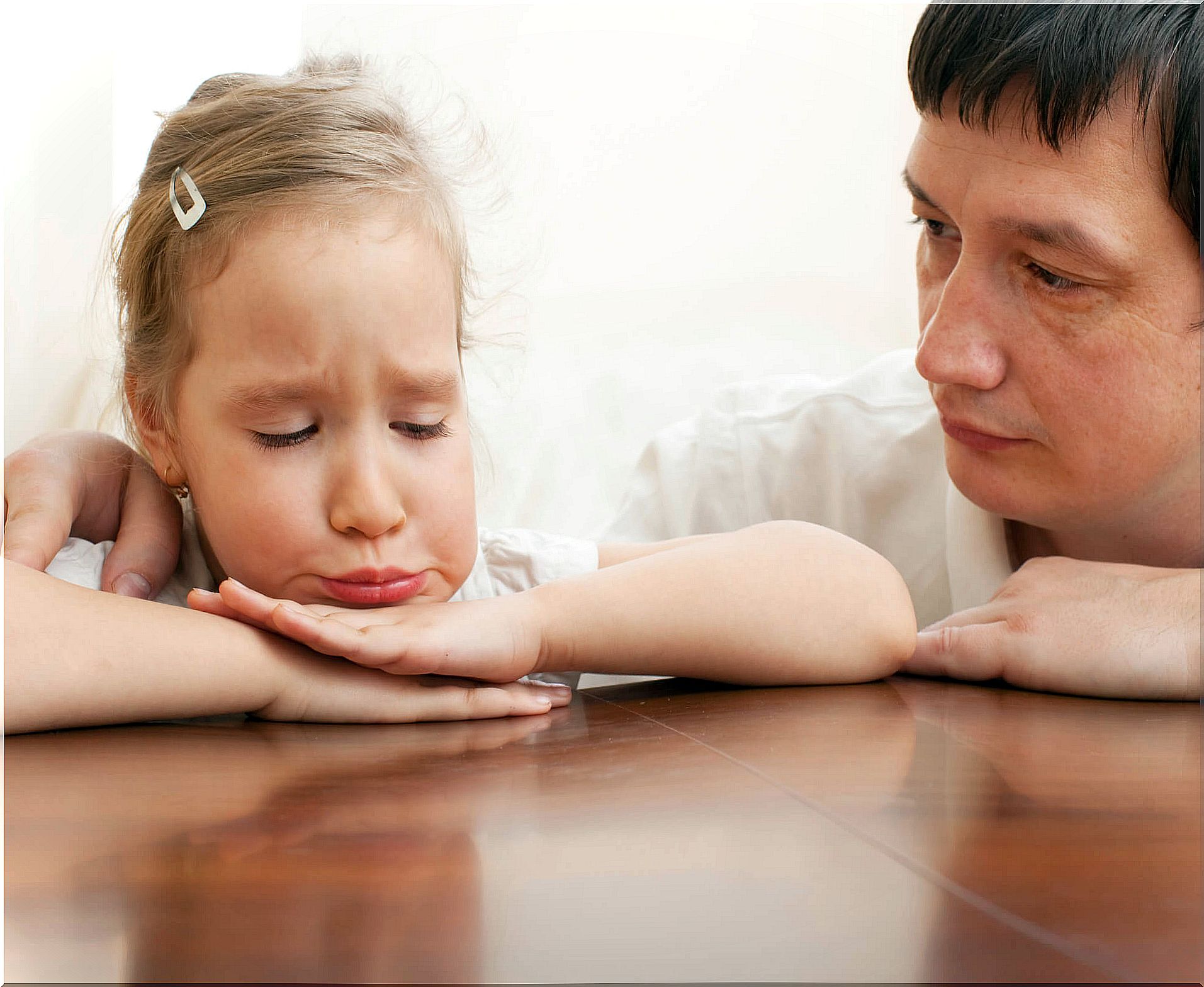 Father comforts a sad girl