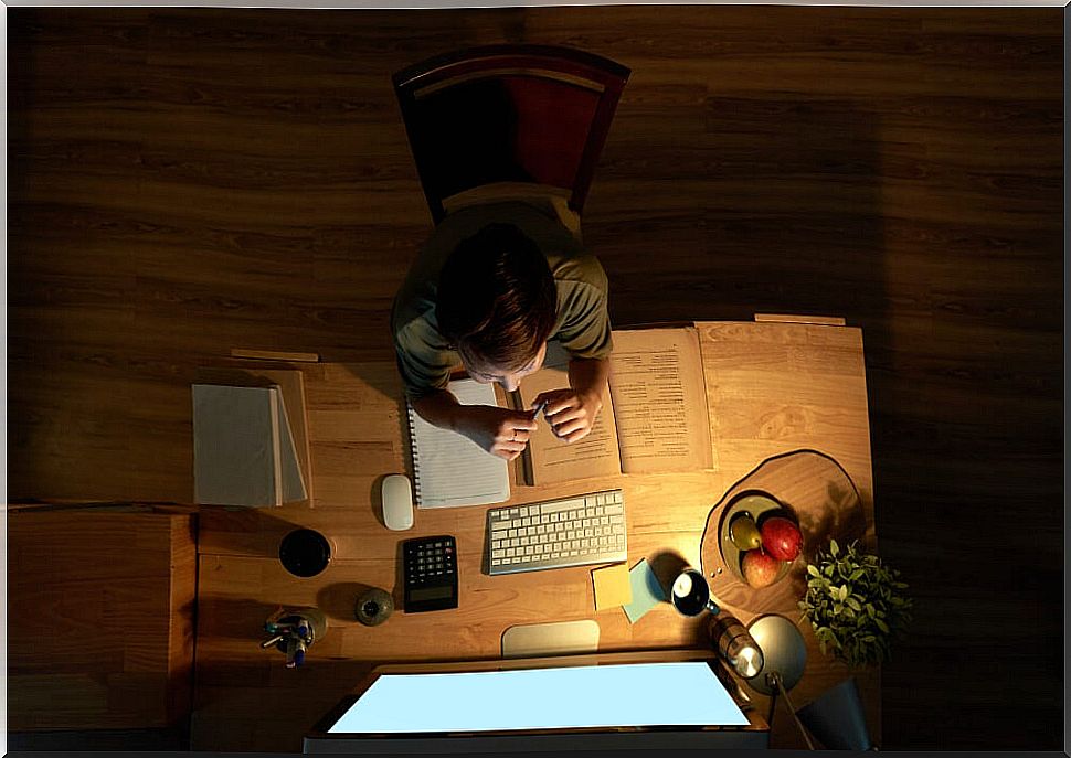 Guy with his well organized desk in his efficient study session.