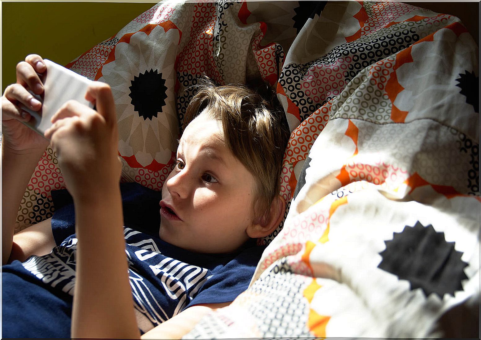 Child playing in bed with mobile.