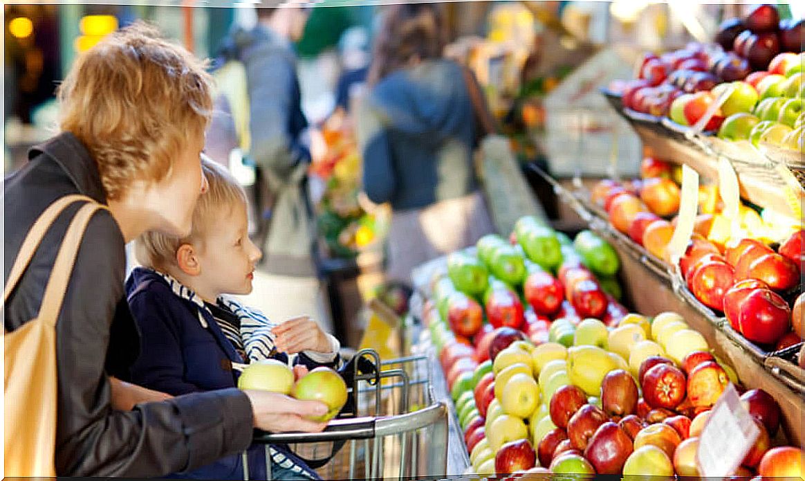 Mother with her son in the supermarket shopping.