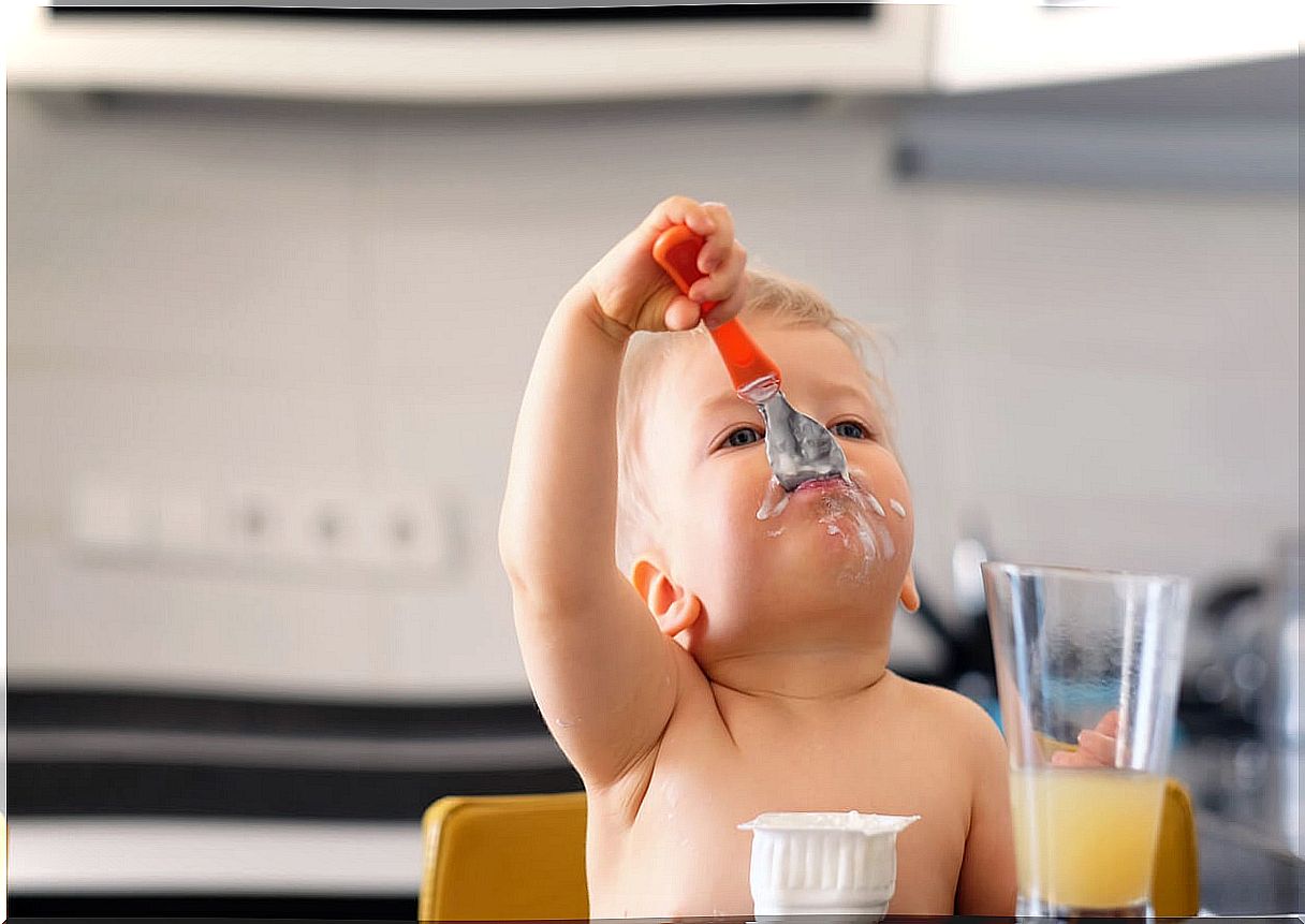 12 month old baby having a yogurt snack.