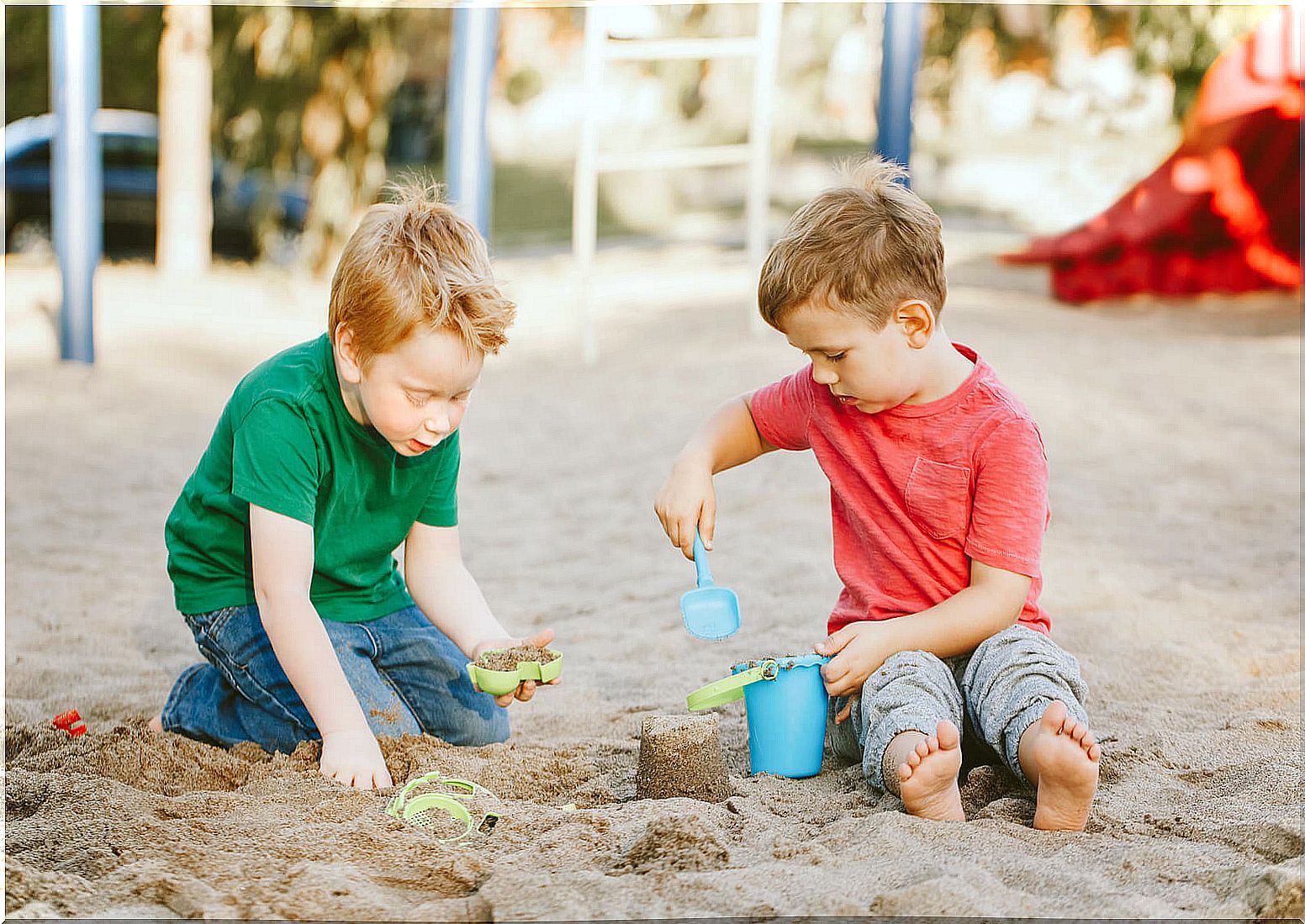 Child playing at making sand castles to encourage gross motor development.