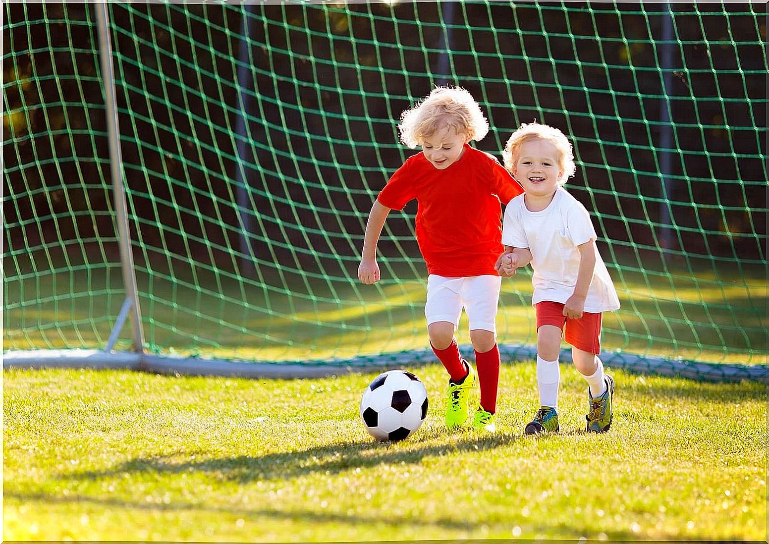 Happy children playing soccer because their parents have an important role in children's sports.