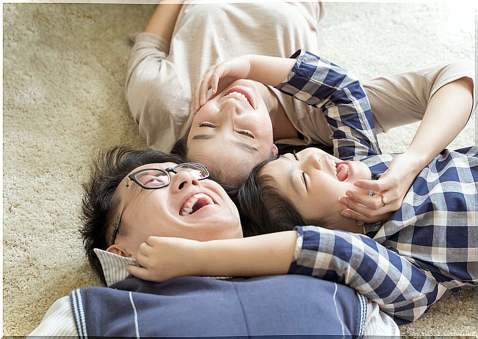 Son hug his father and mother lying on the floor.