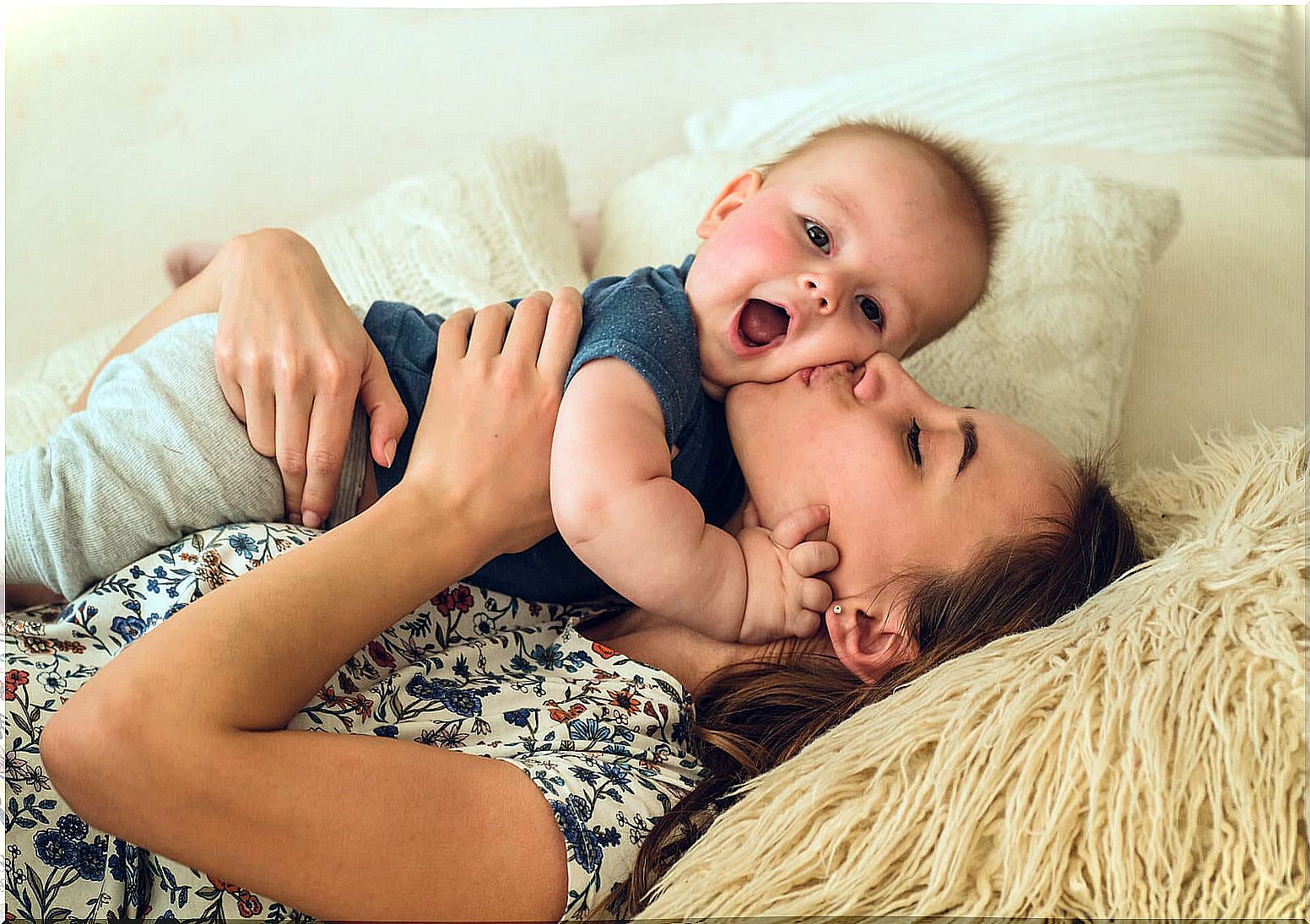 Mom kissing and hugging her baby grateful for the chaos of motherhood.