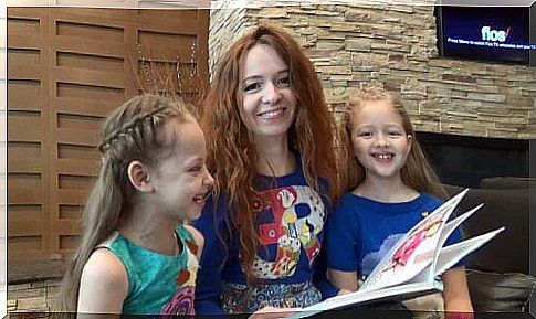 Mother and daughters reading a book because reading is very important during quarantine.